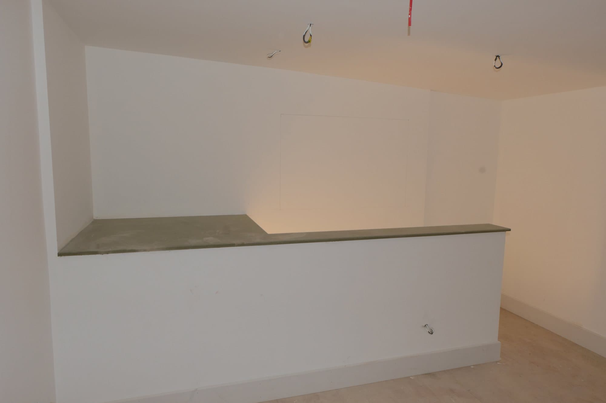 Reception counter under construction with an unfinished stone effect worktop and exposed cabling