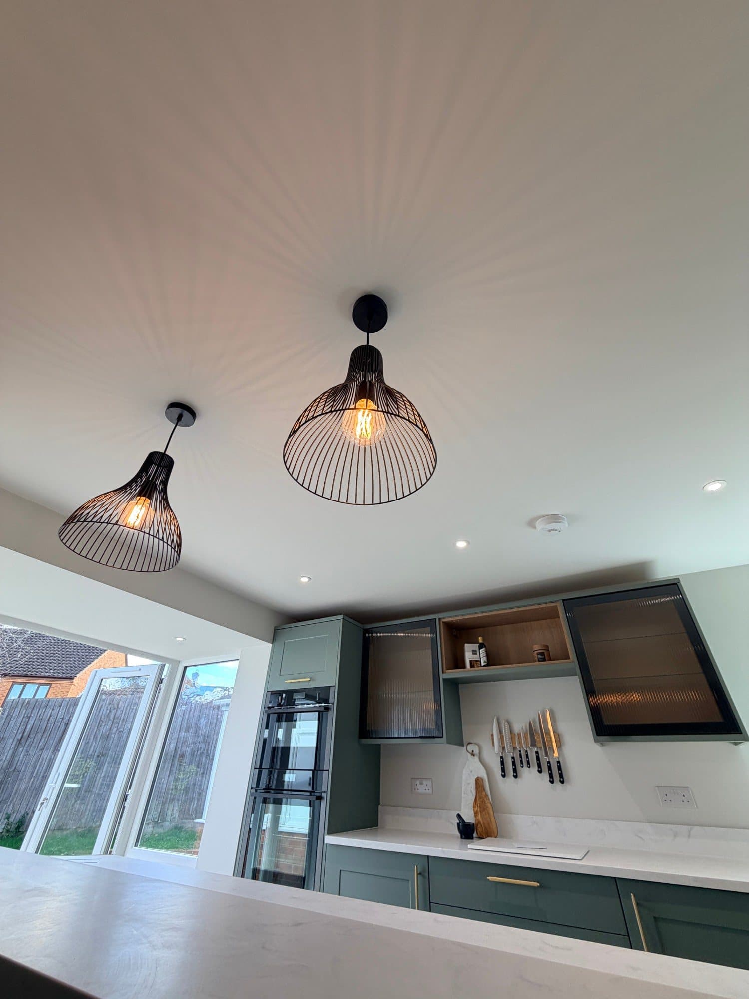 Pair of black wire pendant lights above a kitchen island