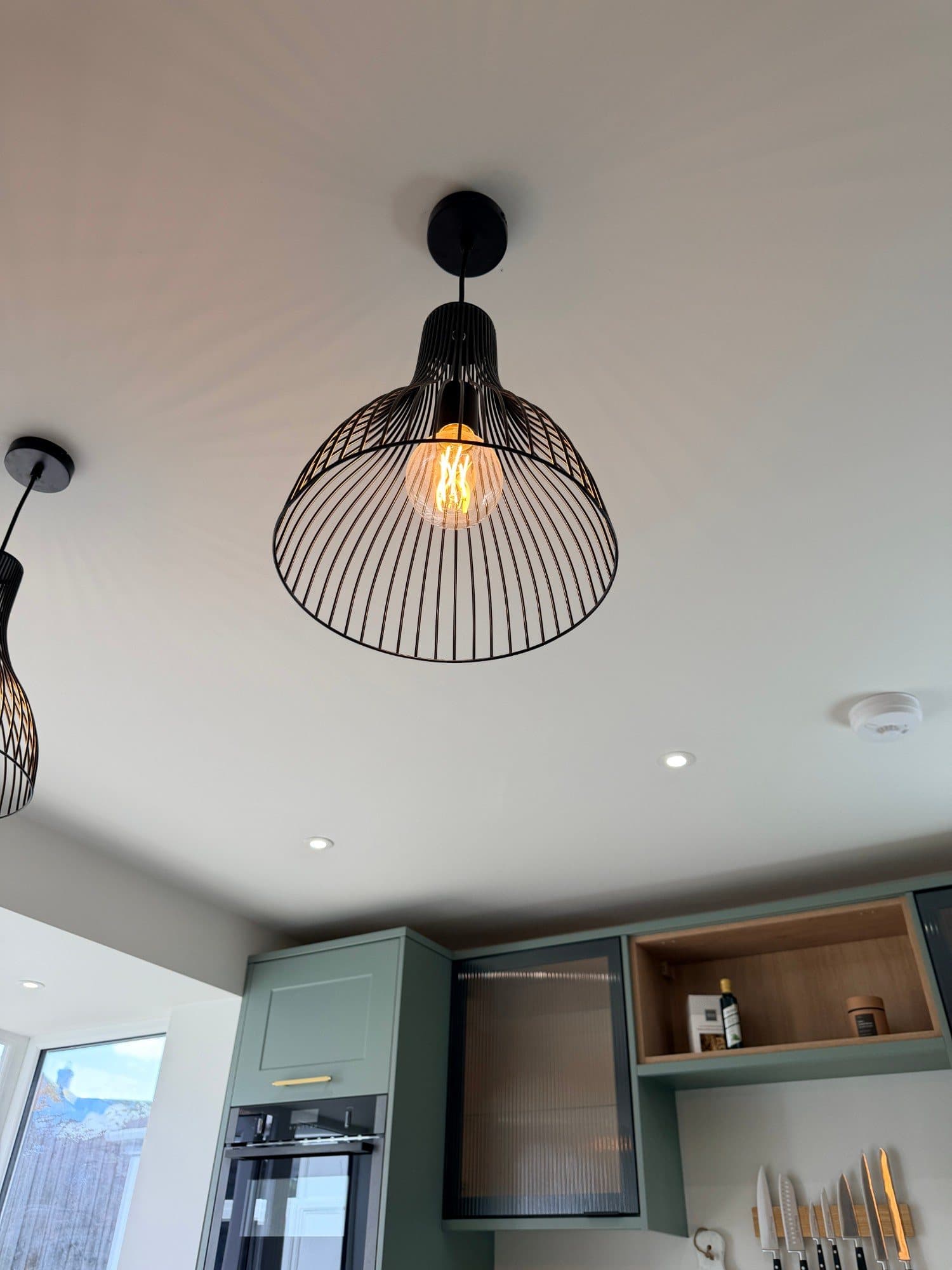 Close-up of a black wire pendant light with exposed filament bulb