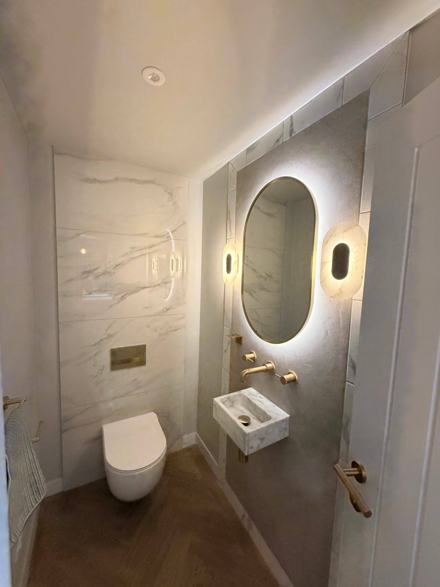Wall-hung toilet and marble wash basin in a downstairs WC