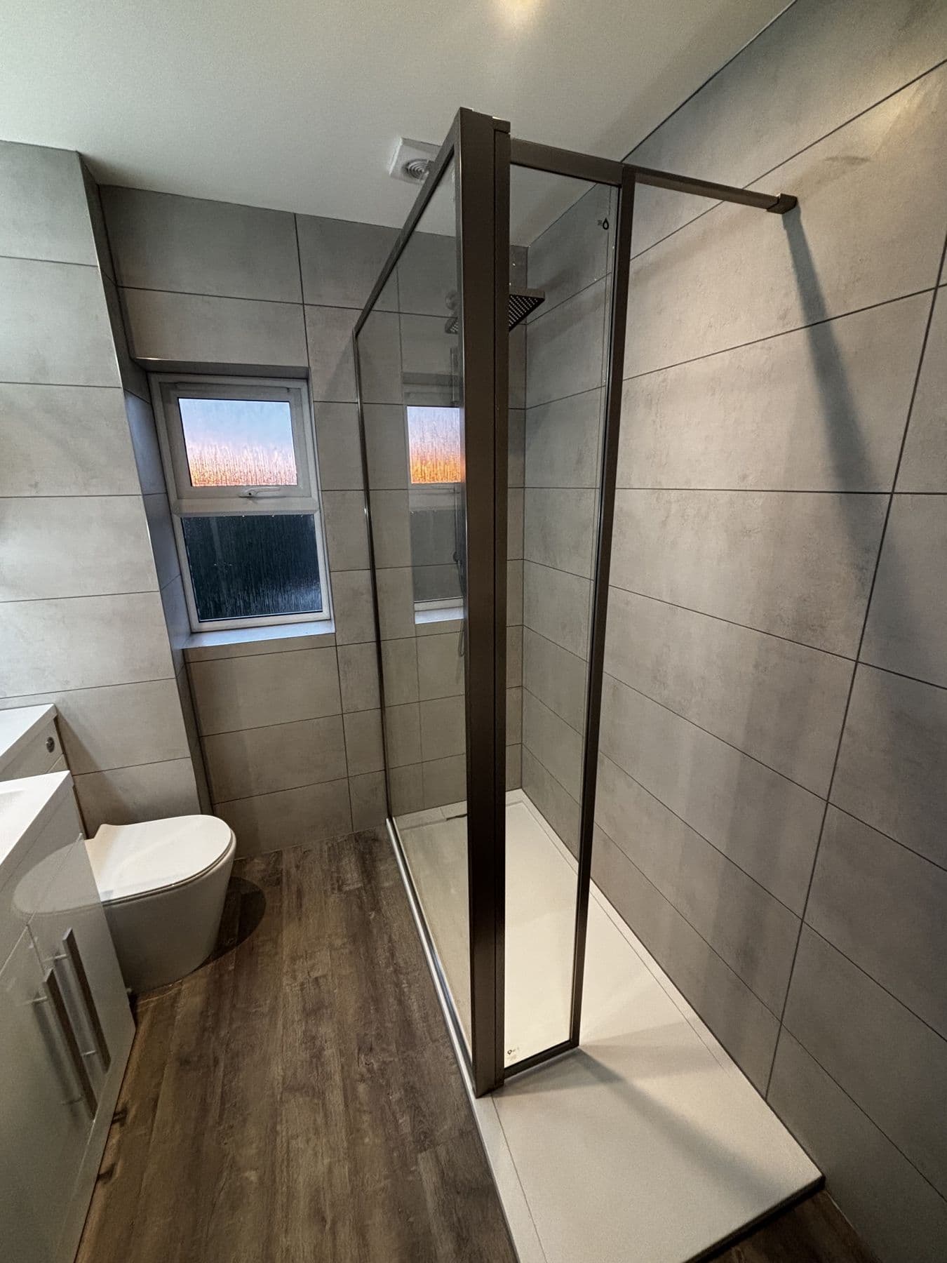 Another angle of the walk in shower enclosure with glass screen, toilet and vanity unit in the background