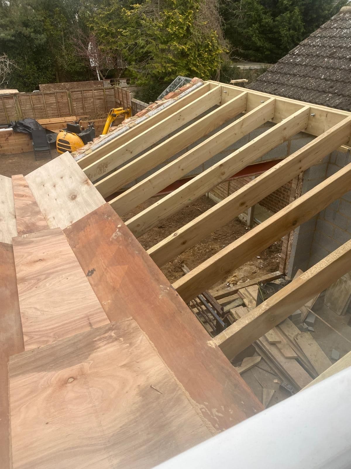 Aerial view of the new roof structure under construction with timber joists and plywood sarking boards